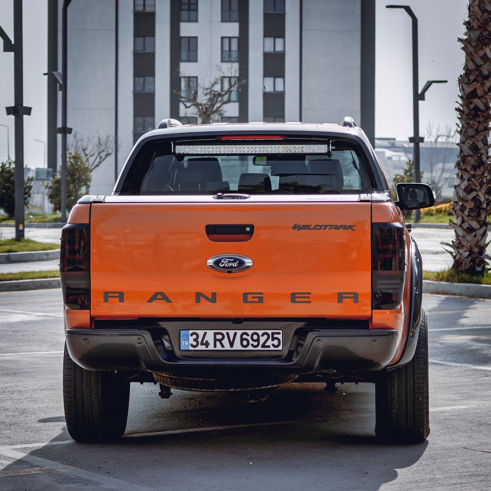 Rear view of an orange pickup truck showing its back glass