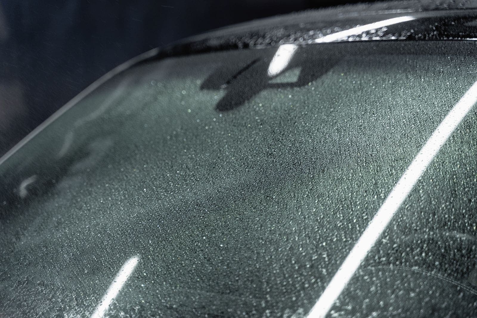Close view of windshield glass with rain beading on the surface
