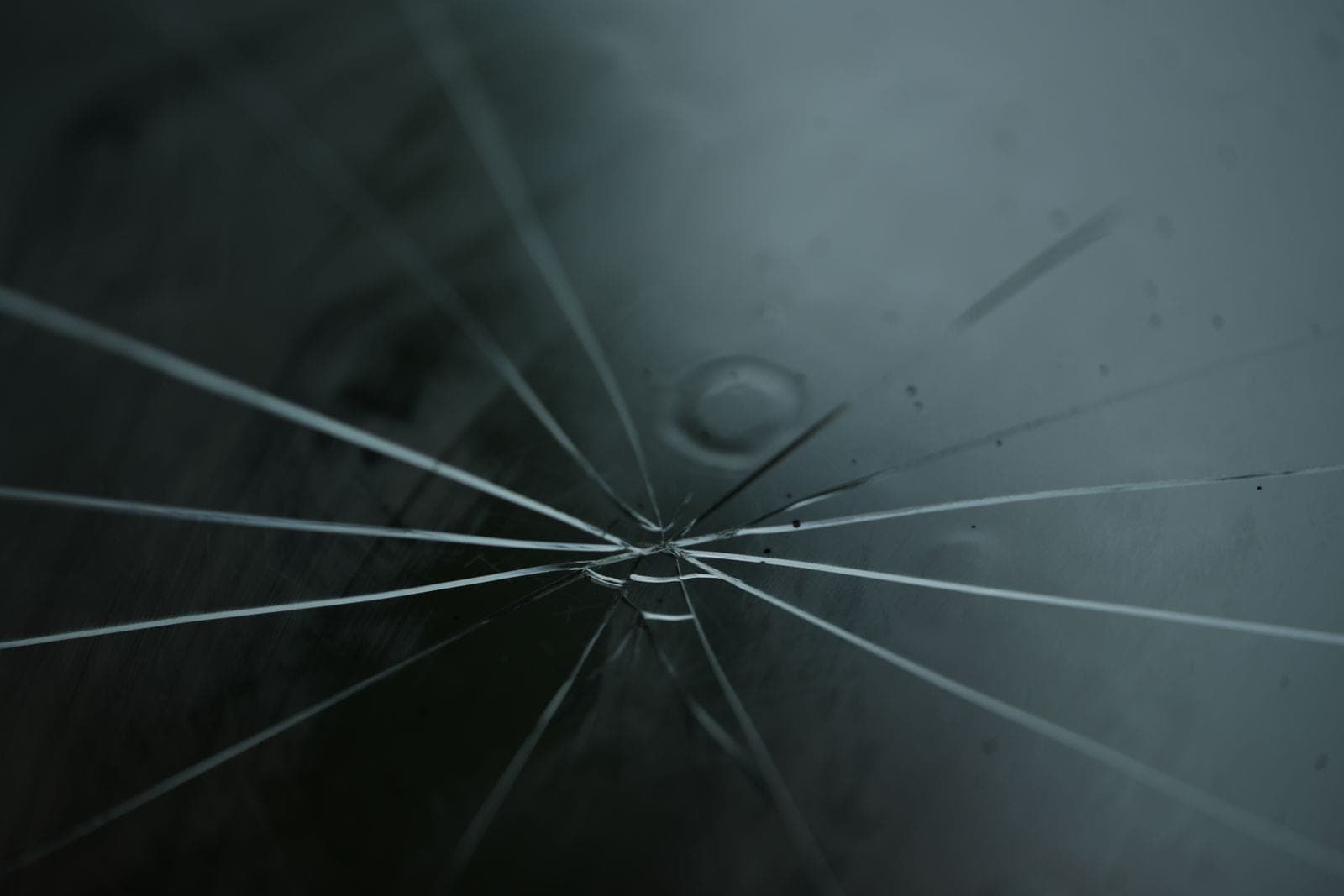 Star-shaped rock chip with cracks radiating across windshield glass