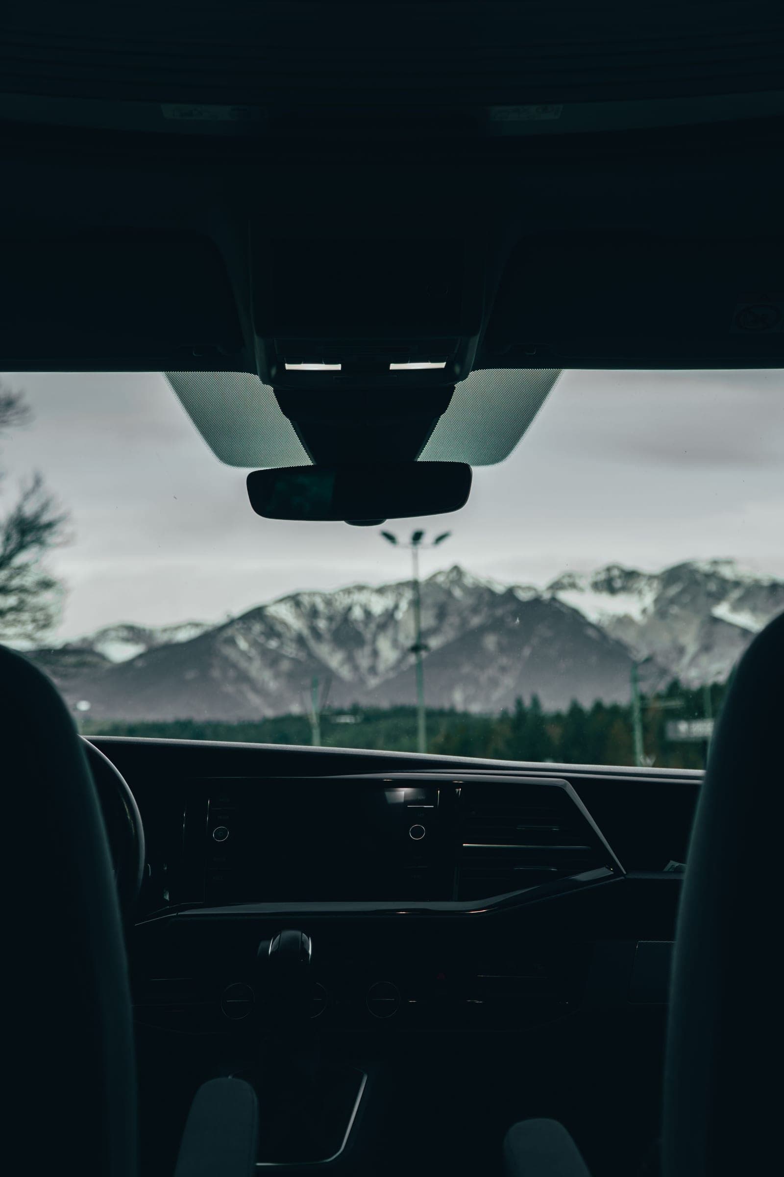 Snowy mountains seen through a clear car windshield